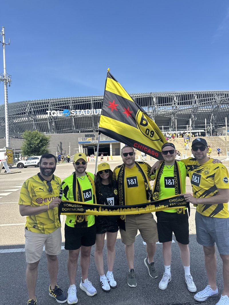 Members with the flag outside the stadium